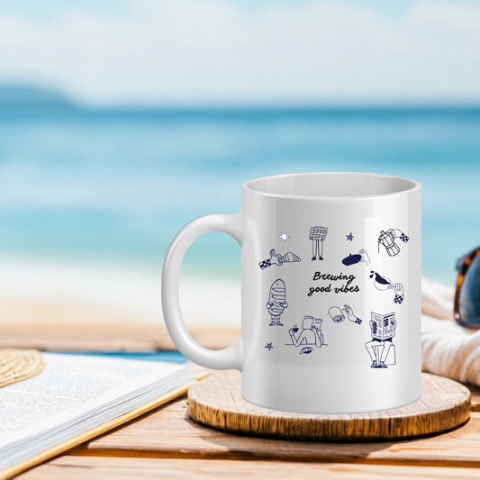 White mug with illustrations and text on a wooden coaster with a beach background
