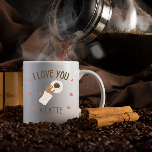 Mug with 'I Love You a Latte' design being filled with coffee, surrounded by coffee beans and cinnamon sticks.